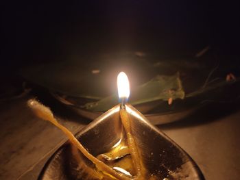 Close-up of burning candle on table