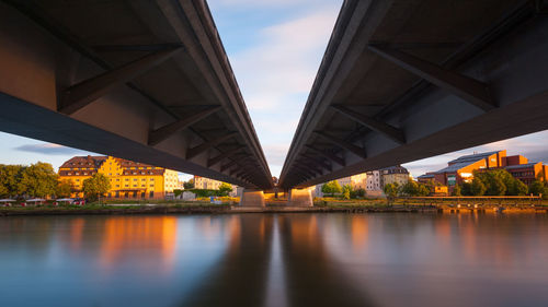 Bridge over river against sky in city