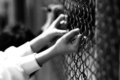 Close-up of woman hand on metal fence