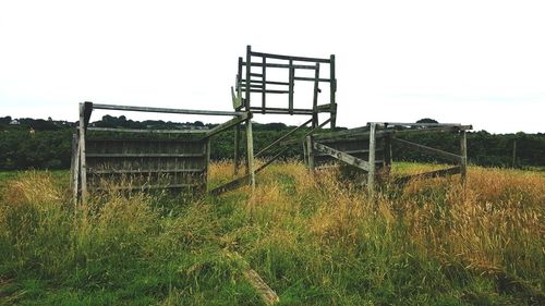 Metallic structure on field against sky