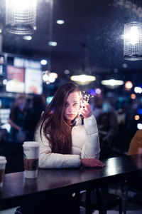 Full length of young woman sitting in restaurant
