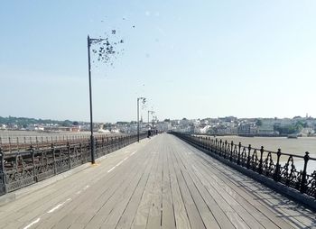 Street amidst city against clear sky