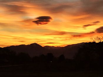 Scenic view of silhouette mountains against orange sky