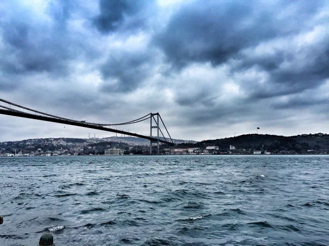 sky, water, cloud - sky, cloudy, connection, built structure, bridge - man made structure, waterfront, architecture, sea, cloud, river, transportation, engineering, overcast, rippled, weather, nature, bridge, suspension bridge