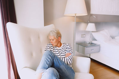Young woman sitting on sofa at home