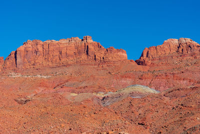 Rock formations on mountain against blue sky