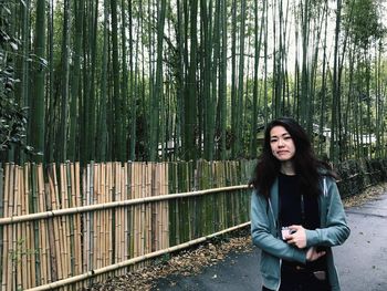 Beautiful young woman standing in a forest