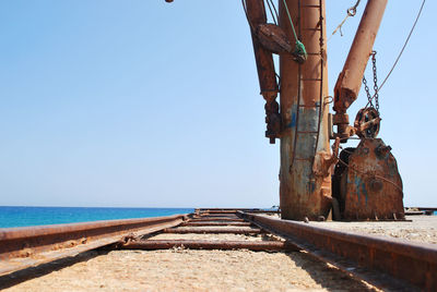 Close-up of railroad track with sea in background