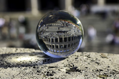 Close-up of crystal ball with coliseum reflection on retaining wall