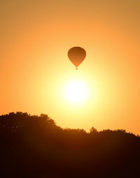 Silhouette hot air balloon against sky during sunset