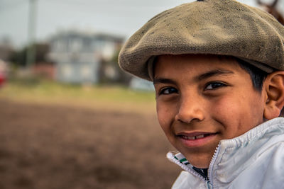 Close-up portrait of smiling boy wearing flat cap