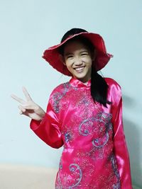 Portrait of happy woman standing against red background