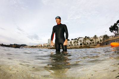 Full length of man standing in sea against sky