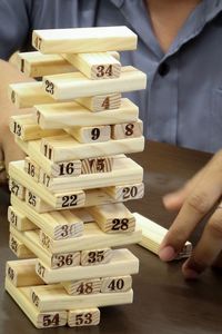 Midsection of playing jenga at table