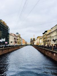 Bridge over river in city against sky