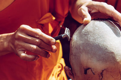 Close-up of man shaving head of boy