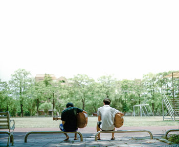 Rear view of couple walking against clear sky