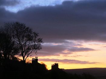 Silhouette trees against sky at sunset