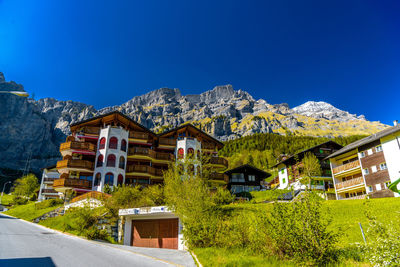 Houses and buildings against clear blue sky