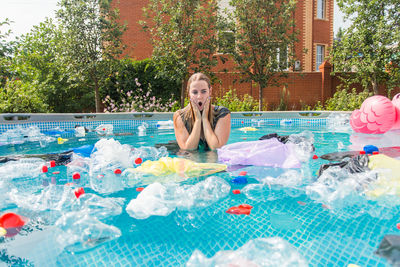 Portrait of smiling young woman swimming in pool