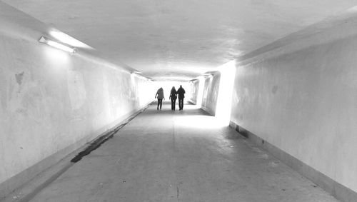 Rear view of woman walking in tunnel