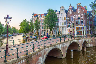 Bridge over canal amidst buildings in city