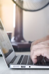 Close-up of person using laptop on table