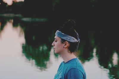 Side view of young woman by lake