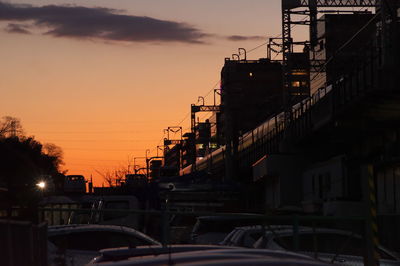 Cars on street against sky during sunset