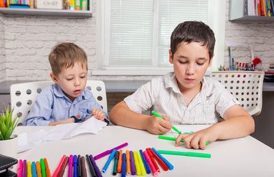 High angle view of boy sitting on table