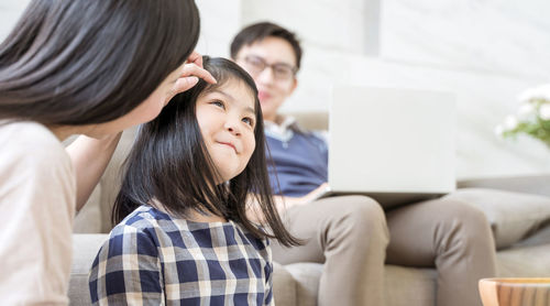 Friends sitting on sofa at home