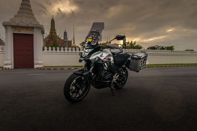 Bicycles on road against buildings at sunset