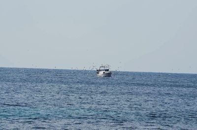 Ship sailing on sea against clear sky