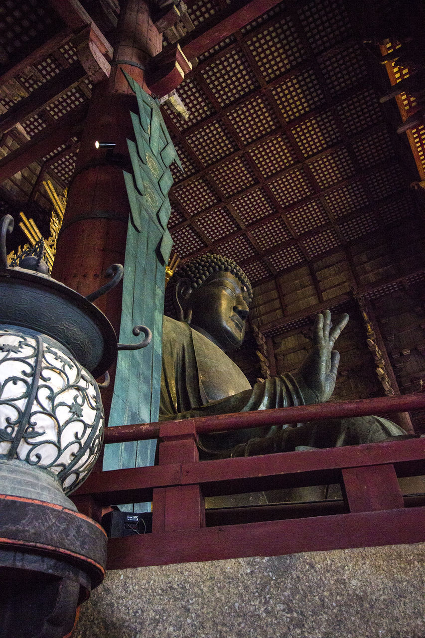 LOW ANGLE VIEW OF STATUE AGAINST TEMPLE BUILDING AND WALL