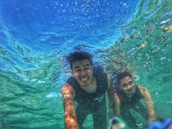 Portrait of shirtless man swimming in sea