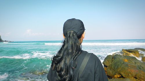 Rear view of woman looking at sea against sky