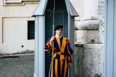 Portrait of smiling man standing against building