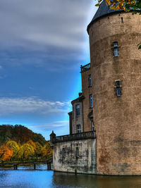 Building by river against sky