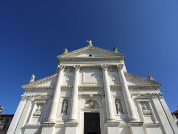 Low angle view of historical building against clear blue sky