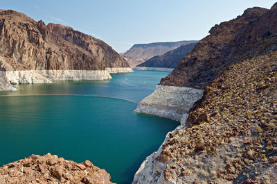 Scenic view of sea and mountains against blue sky