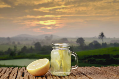 Drink on table against sky during sunset