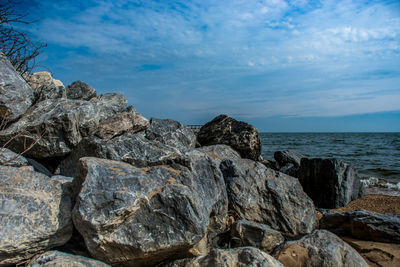 Rocks by sea against sky