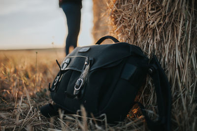 Close-up of bag by hay bale on field