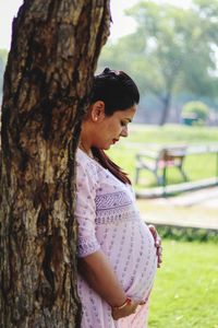 Pregnant woman standing at park