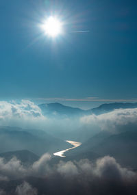 Scenic view of mountains against sky on sunny day