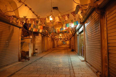 Illuminated alley amidst buildings at night