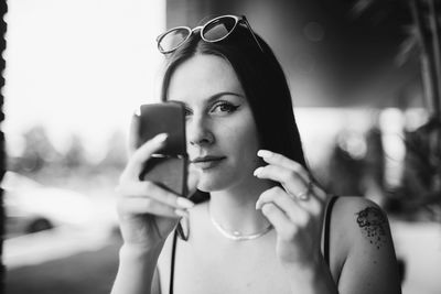 Close-up of young woman checking make-up