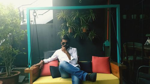 Young man using mobile phone while sitting outdoors