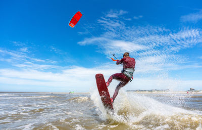 Rear view of man kiteboarding in sea