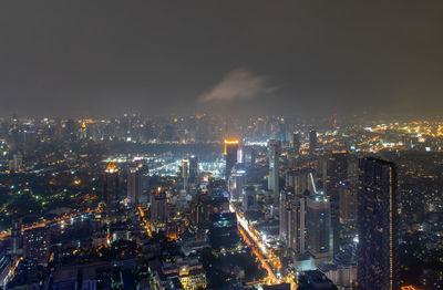 High angle view of illuminated cityscape against sky at night